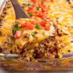 Close-up of a square serving of Mexican casserole being lifted