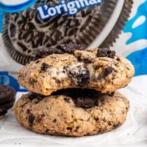 oreo cheesecake cookies stacked on top of parchment paper.