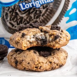 oreo cheesecake cookies stacked on top of parchment paper.