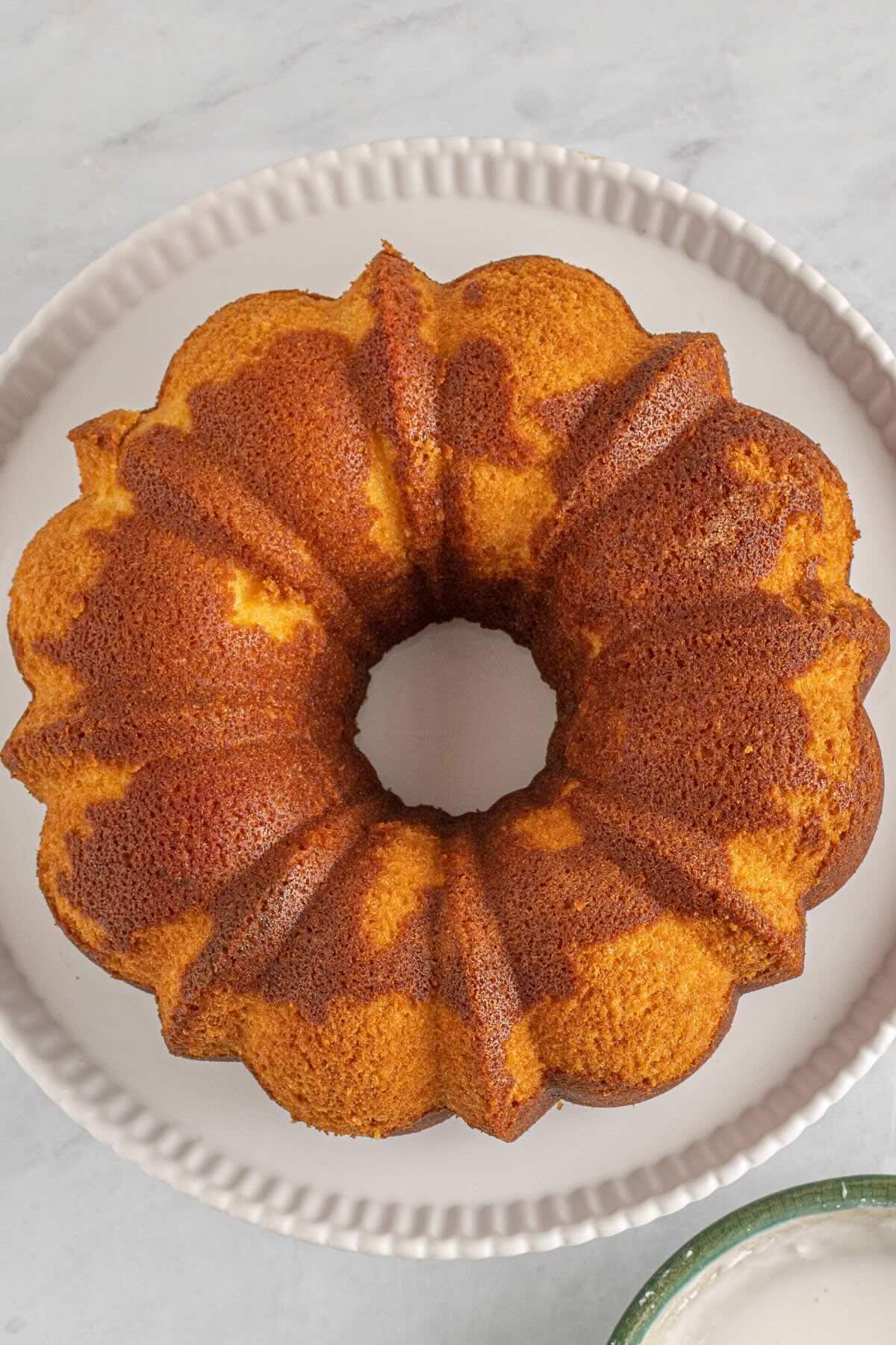 Baked 7UP pound cake unmolded onto a white cake stand.
