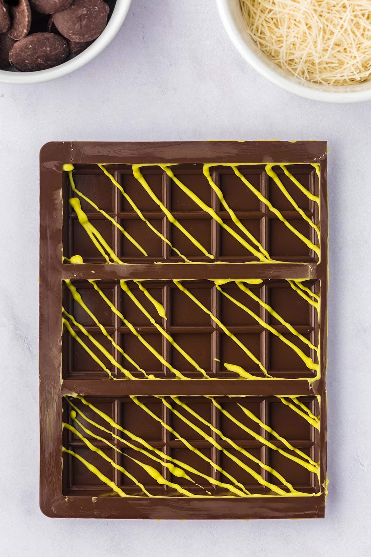 Dubai chocolate bar with yellow drizzle on a light gray background