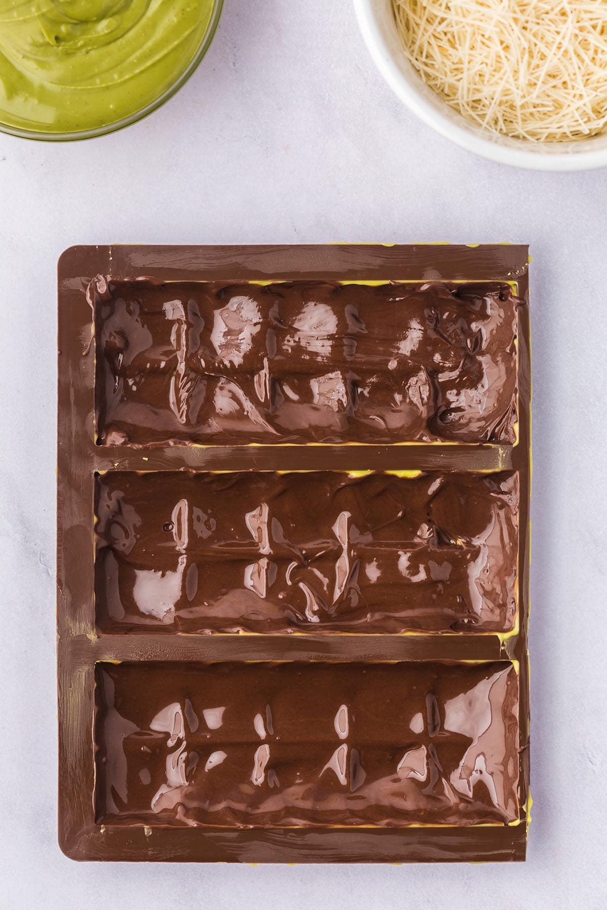 Chocolate bar mold filled with melted dark chocolate.