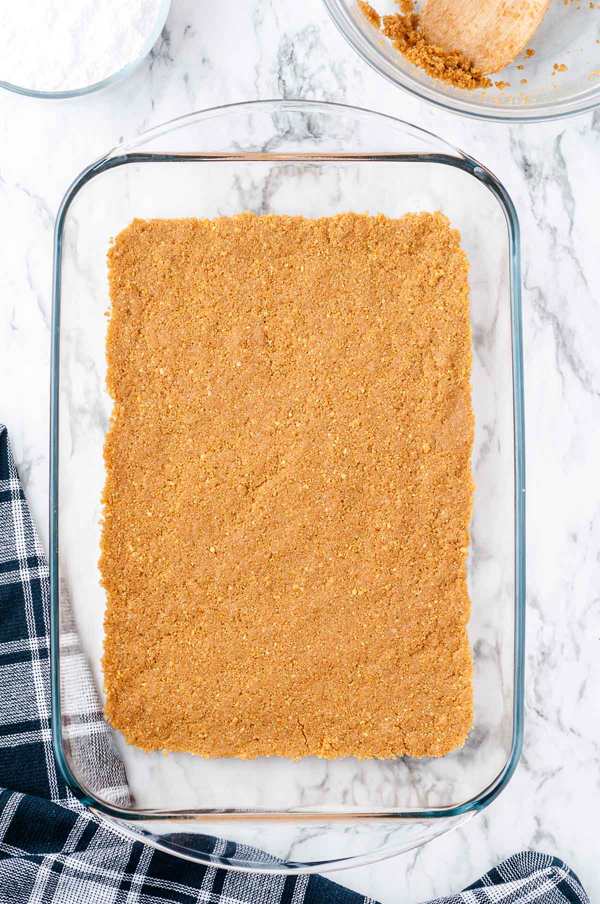 Graham cracker crust pressed into a glass 9x13 baking dish for banana split cake.