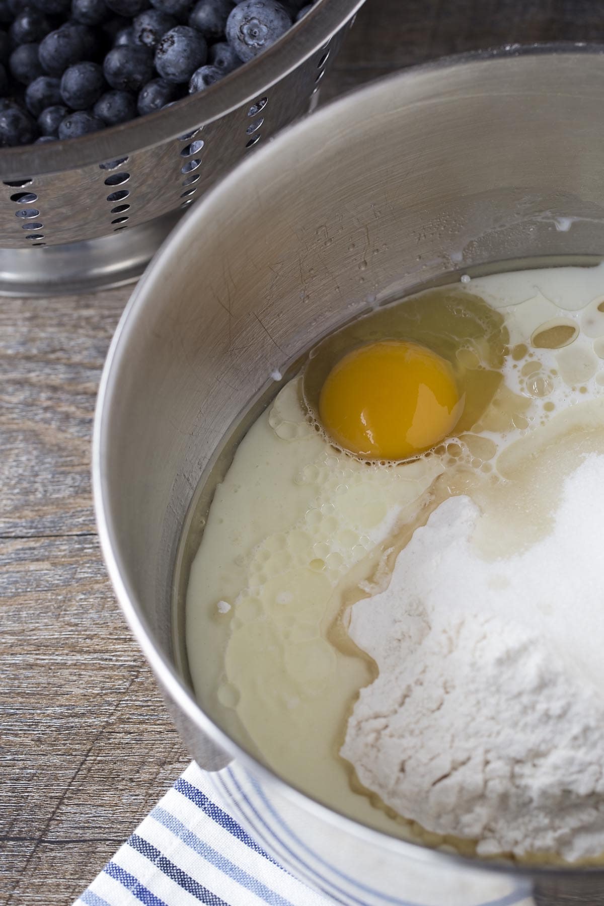 Mixing bowl with egg, milk, and flour for muffins.