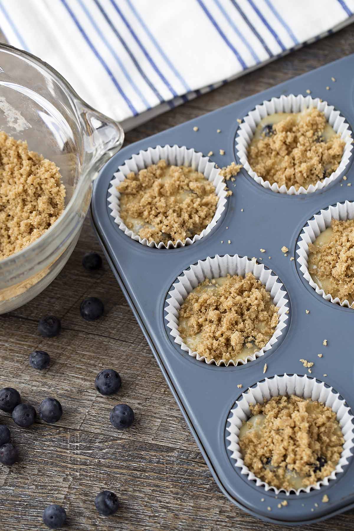Muffin batter topped with brown sugar crumble before baking.