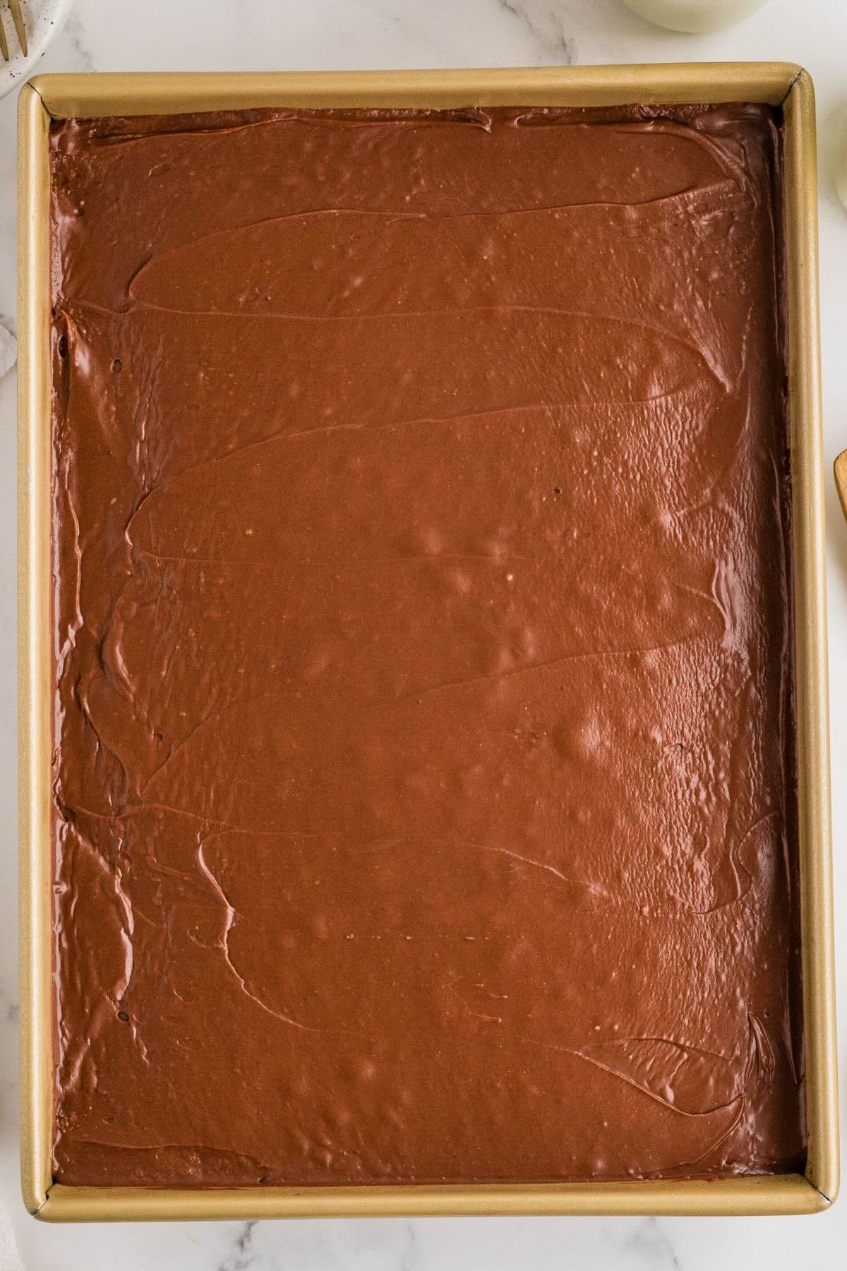 Frosted brownies spread evenly in a rectangular baking pan.
