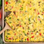 Sheet pan veggie egg bake with peppers, mushrooms, and green onions, cut into squares.