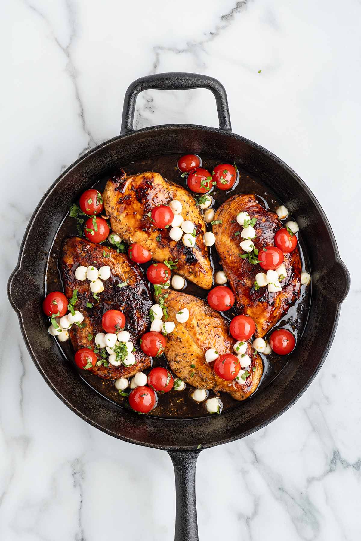 Chicken topped with tomato-mozzarella mixture, ready to go into the oven.