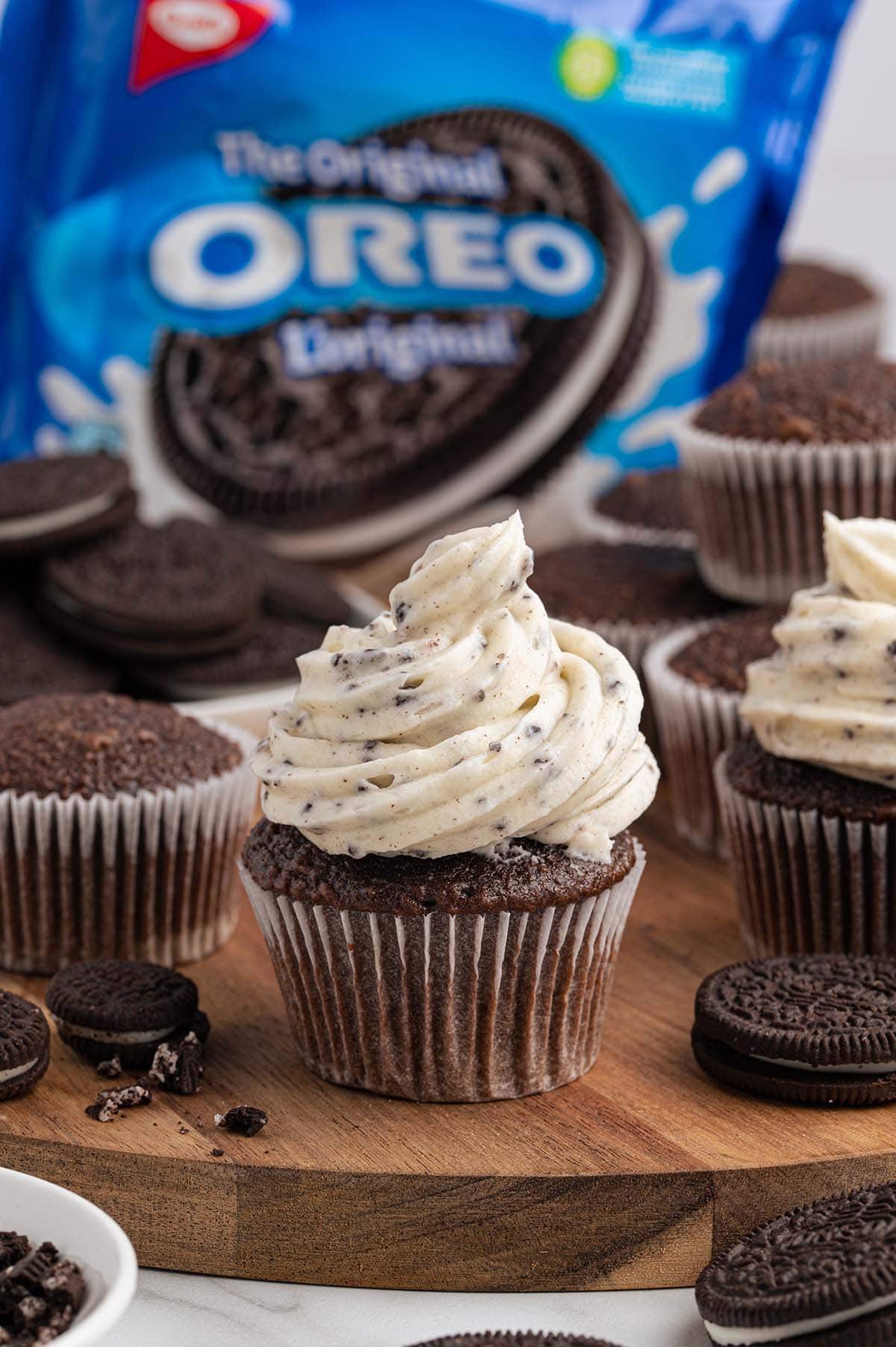 Chocolate cupcakes with cookies and cream frosting, surrounded by Oreo cookies.