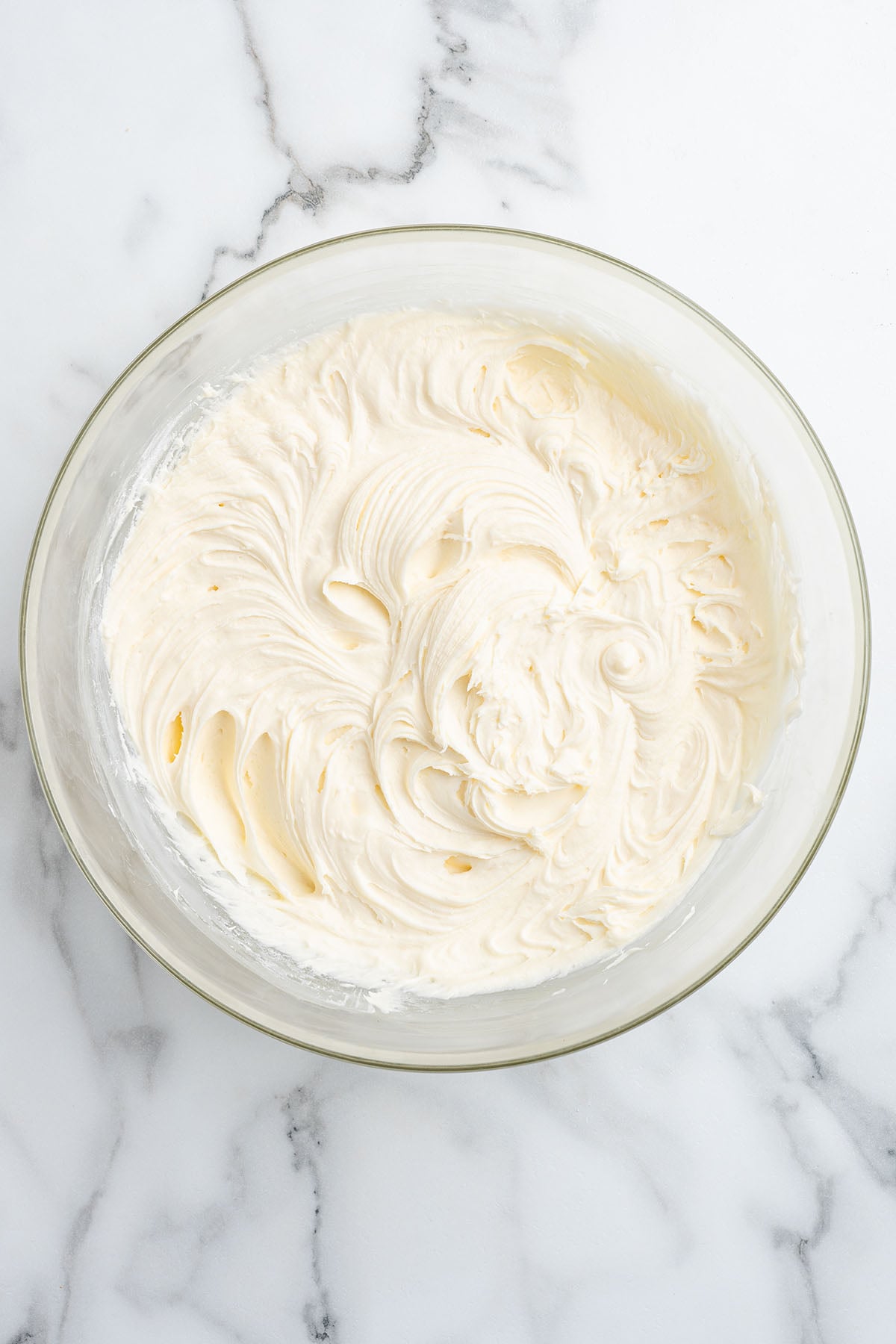 Creamy vanilla frosting in a mixing bowl.
