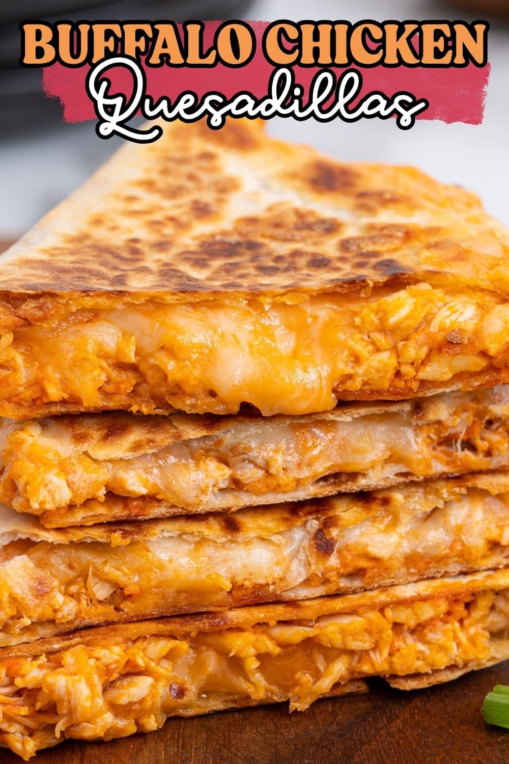 Close-up stack of buffalo chicken quesadilla wedges with melted cheddar cheese oozing out.