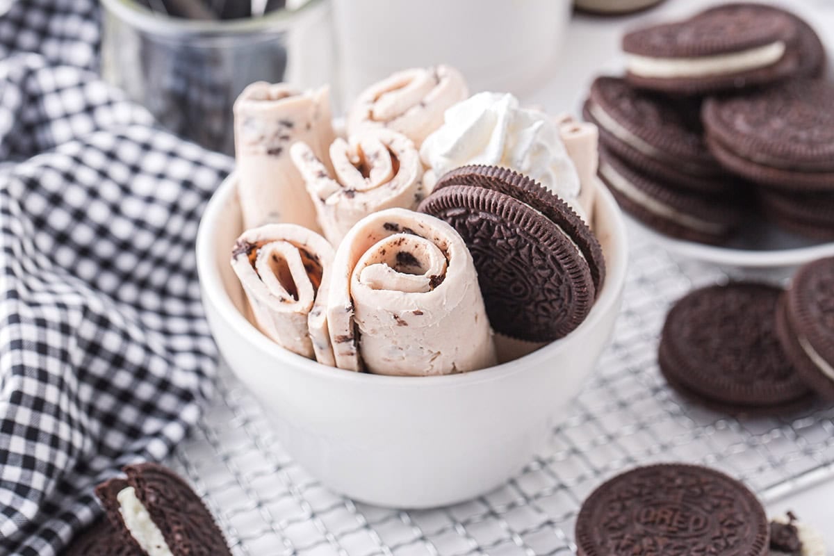 Rolled Oreo ice cream served with whipped cream and Oreo cookies.