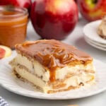 Slice of caramel apple eclair cake layered with creamy filling, graham crackers, and rich caramel topping.