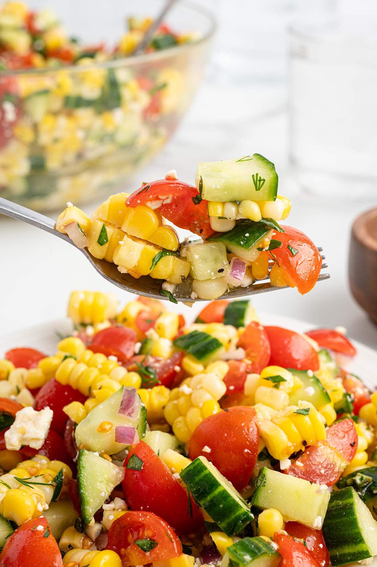 eating corn salad with a fork.