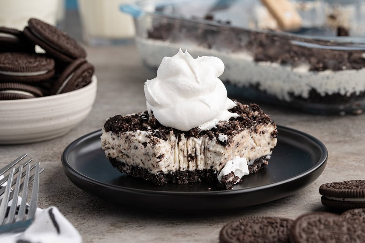 Slice of frozen Oreo dessert topped with whipped cream.