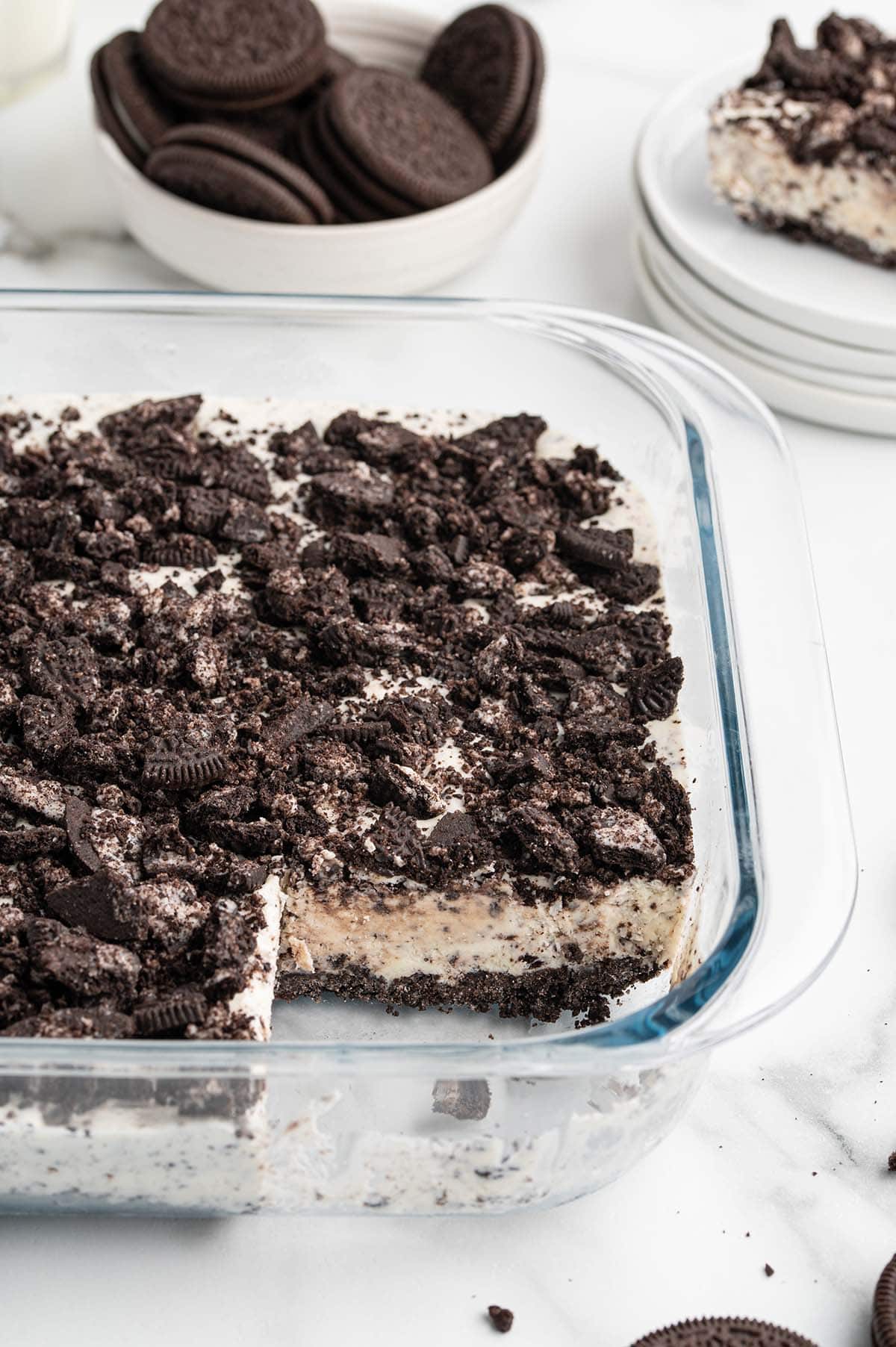 Frozen Oreo dessert in a baking dish topped with crushed cookies.