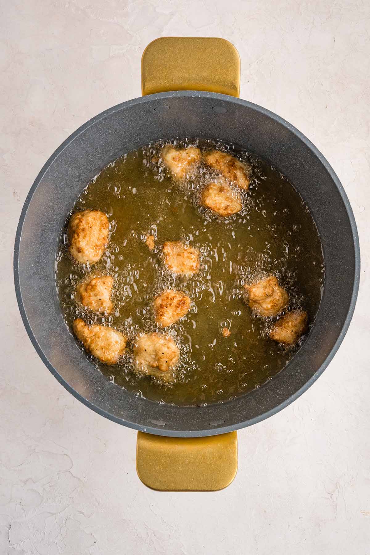 Fry the chicken nuggets in hot oil until golden brown and cooked through, about 3&ndash;4 minutes per batch.