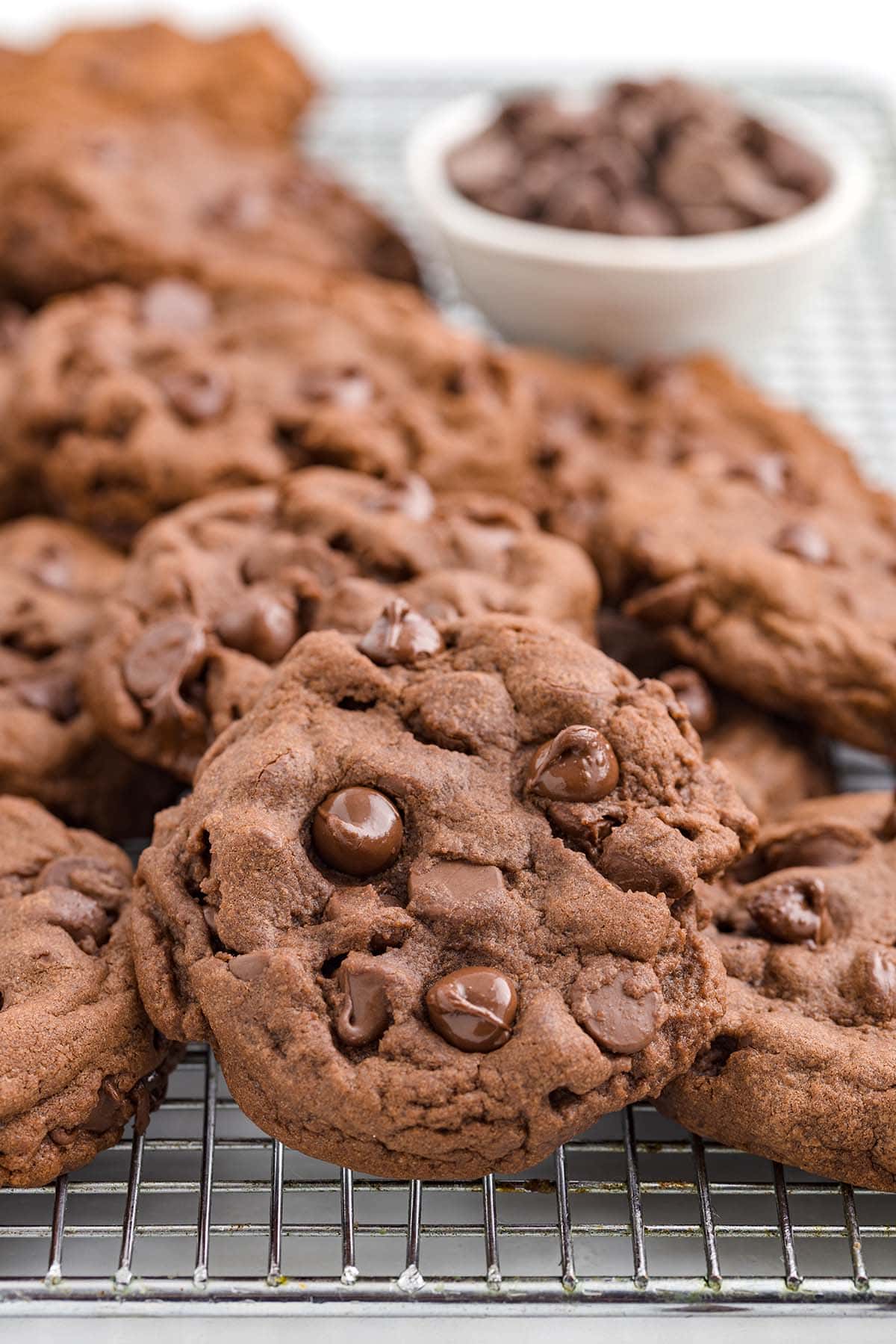 Chocolate Pudding Cookies loaded with melted chocolate chips cooling on a wire rack.