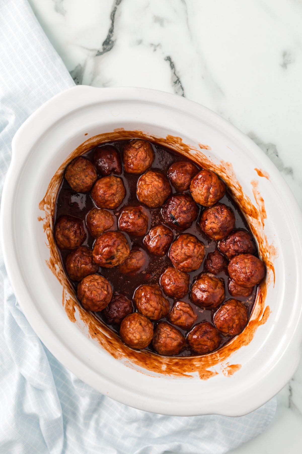 Slow cooker grape jelly meatballs coated in a thick, glossy sweet and savory sauce.