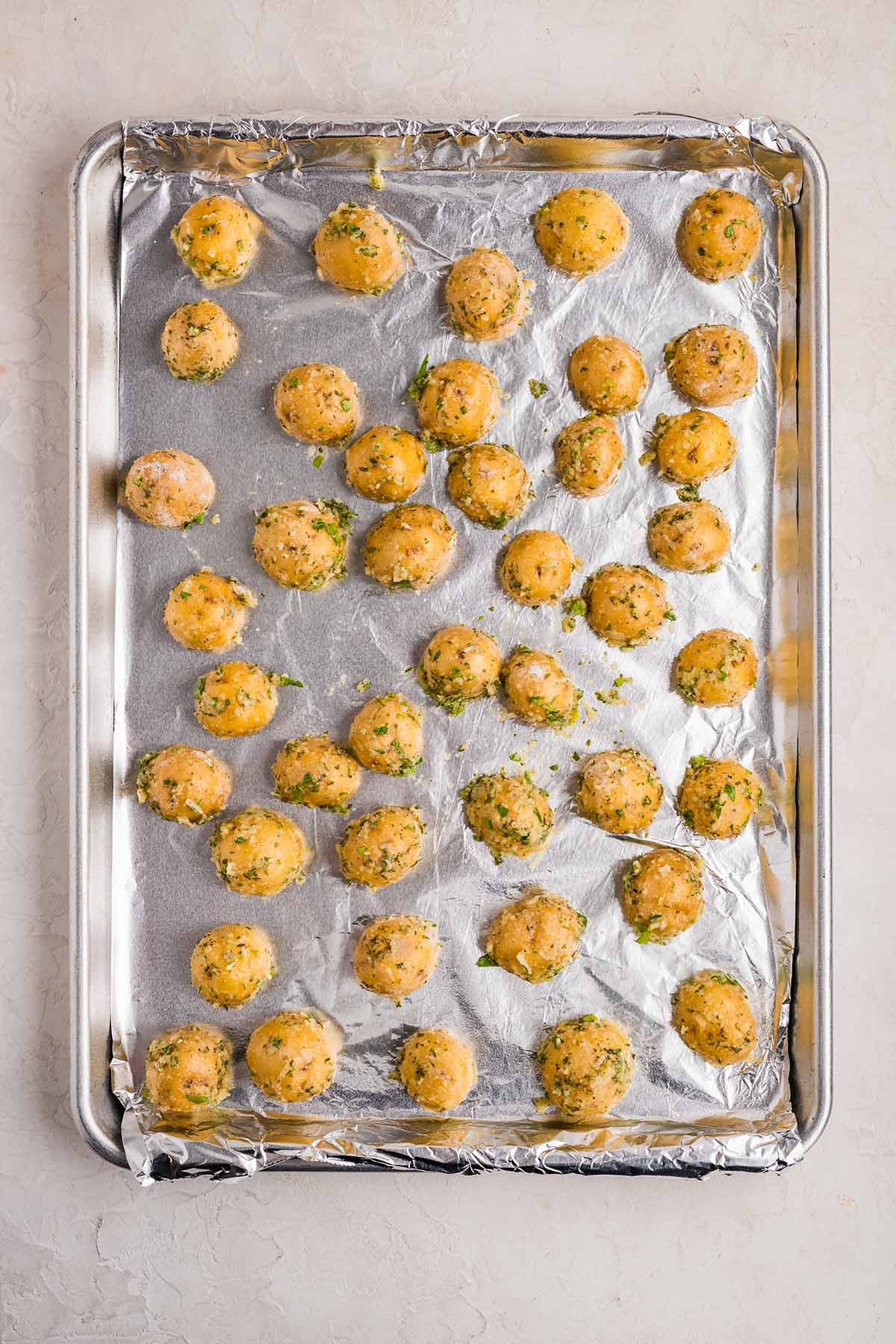 Seasoned ranch potatoes arranged on a baking sheet, ready for the oven.