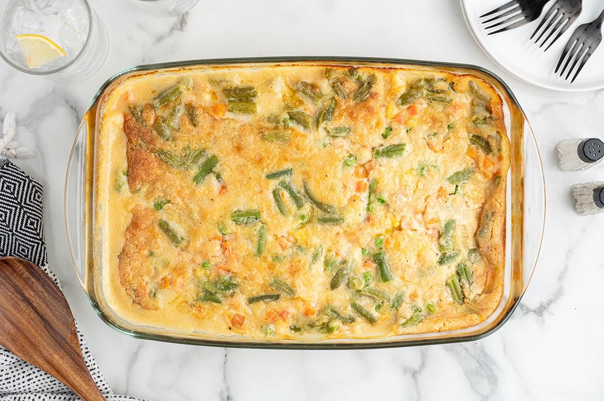 Baked chicken cobbler with golden biscuit topping in a dish.