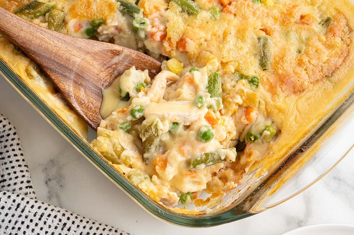 Close-up of chicken cobbler scooped with a wooden spoon.