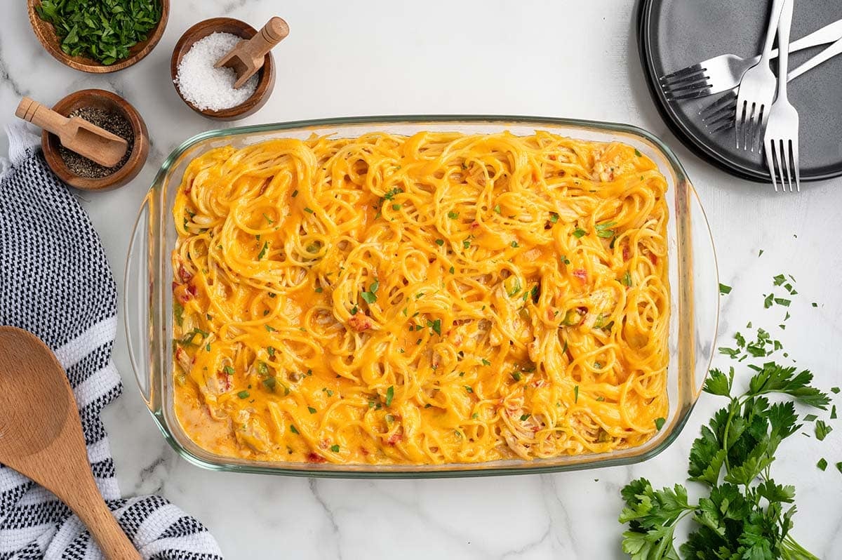 Baked Rotel chicken spaghetti casserole topped with melted cheese and parsley.