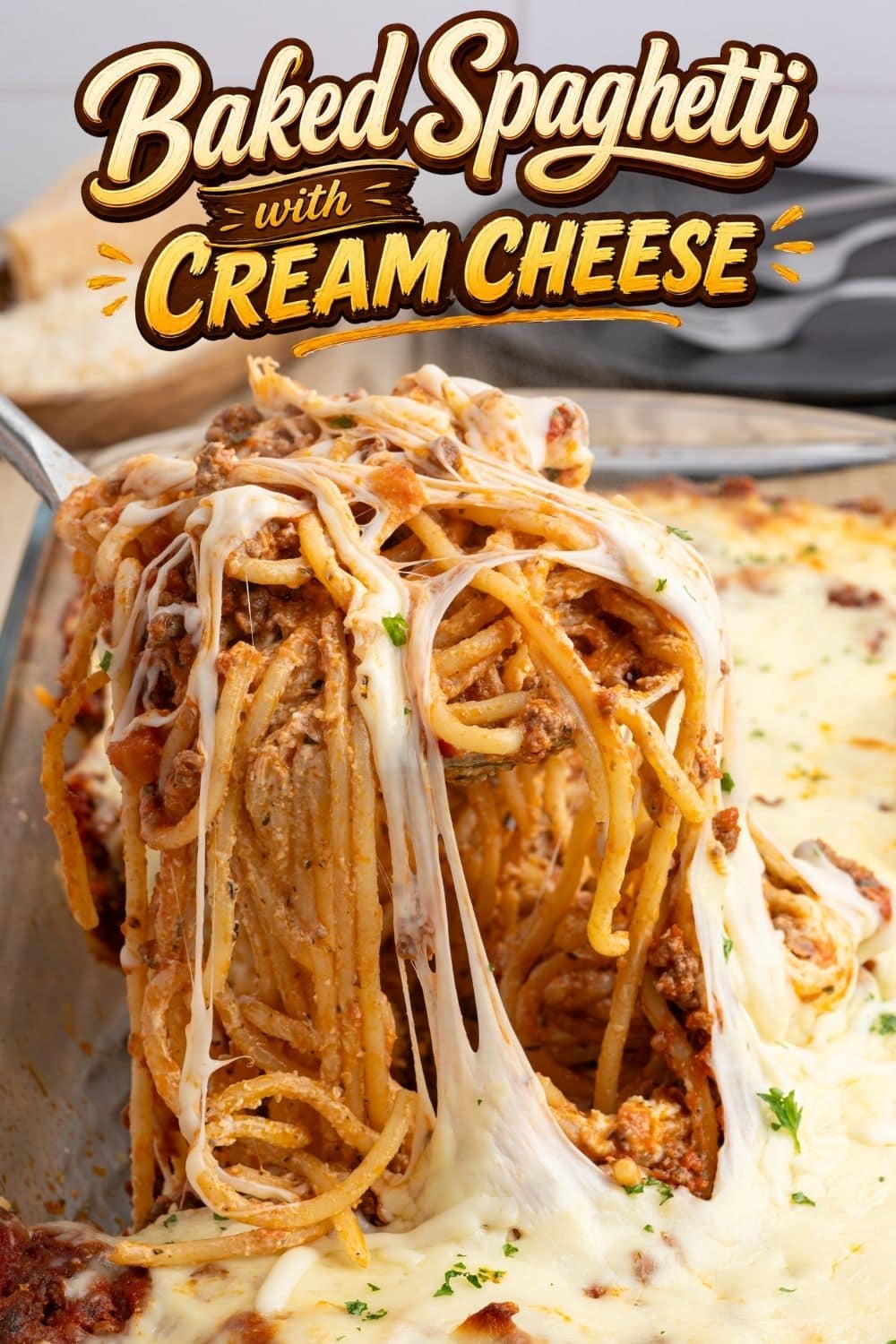Close-up of baked spaghetti with cream cheese pulling up in a cheesy strand from the dish.
