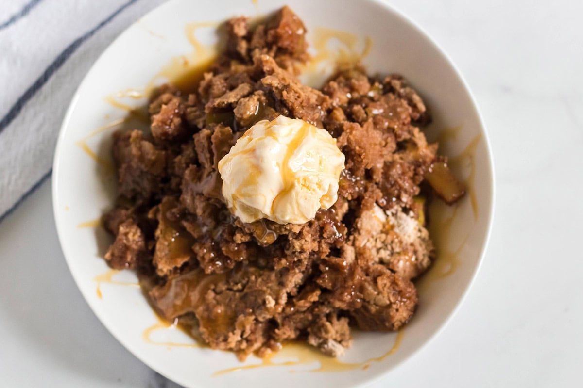 Apple dump cake with vanilla ice cream and caramel drizzle.