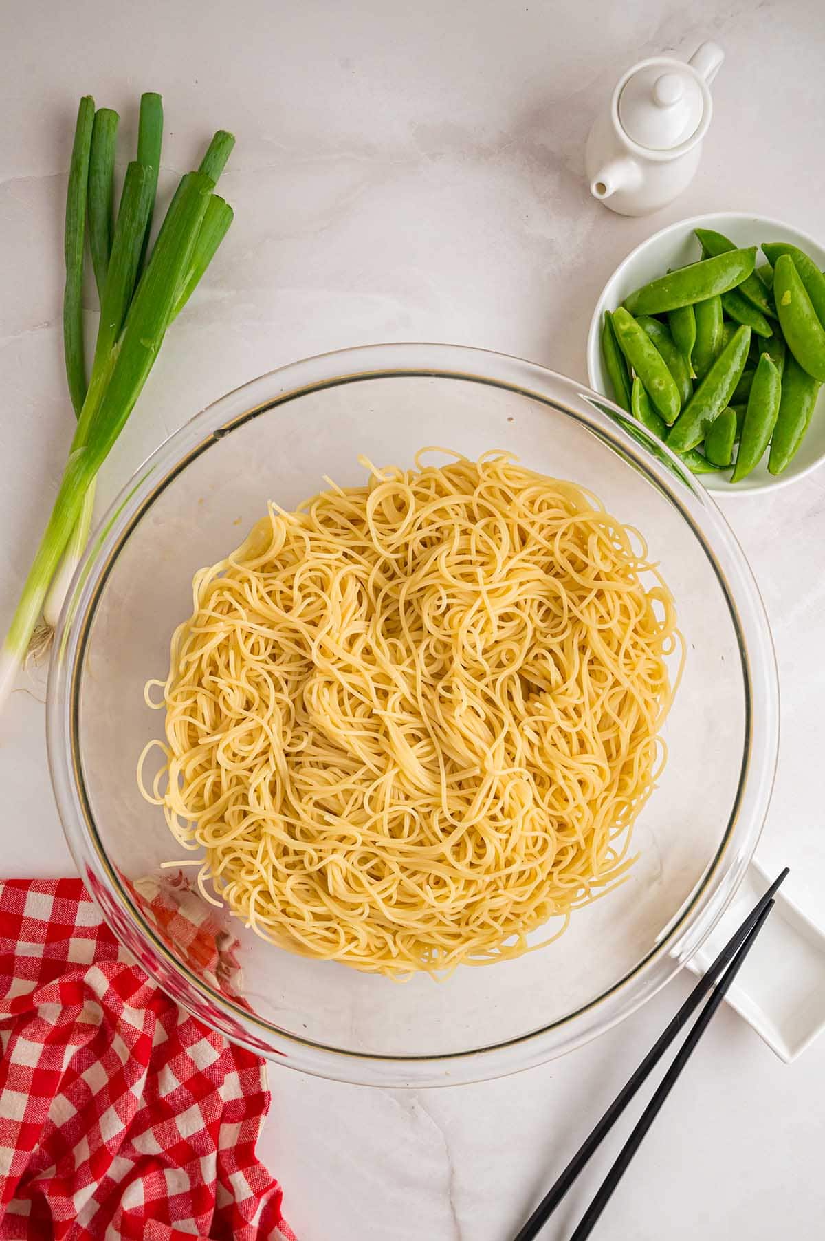 Cooked noodles in a glass bowl ready to toss.