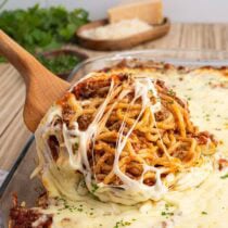 Cheesy baked spaghetti served with meat sauce and melted mozzarella.