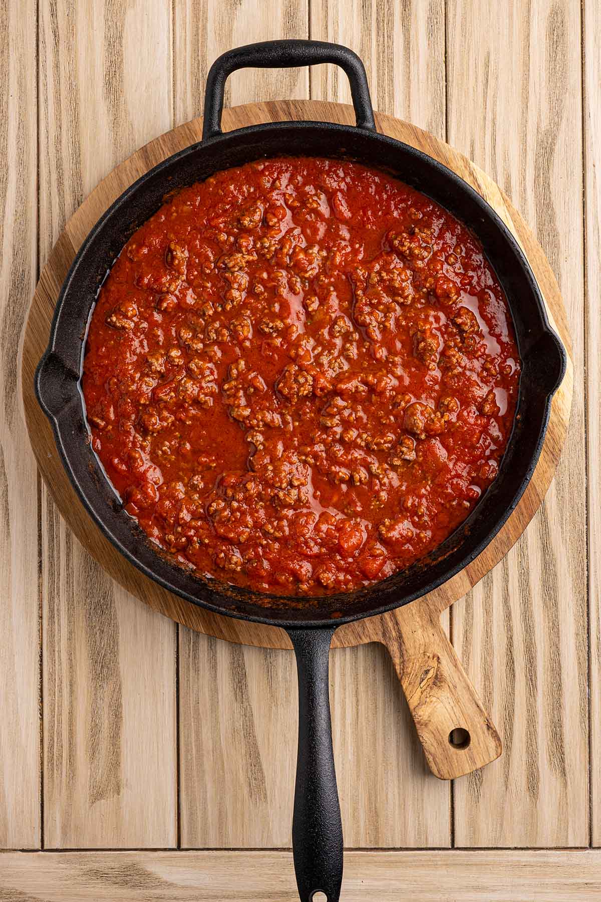 Homemade meat sauce simmering in a cast iron skillet.