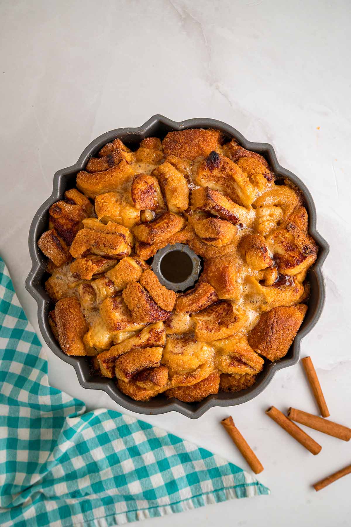 Freshly baked cinnamon roll monkey bread in a Bundt pan with a golden brown, caramelized cinnamon sugar coating.