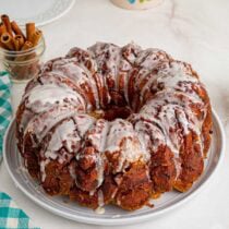 Glazed cinnamon roll monkey bread served on a white plate.