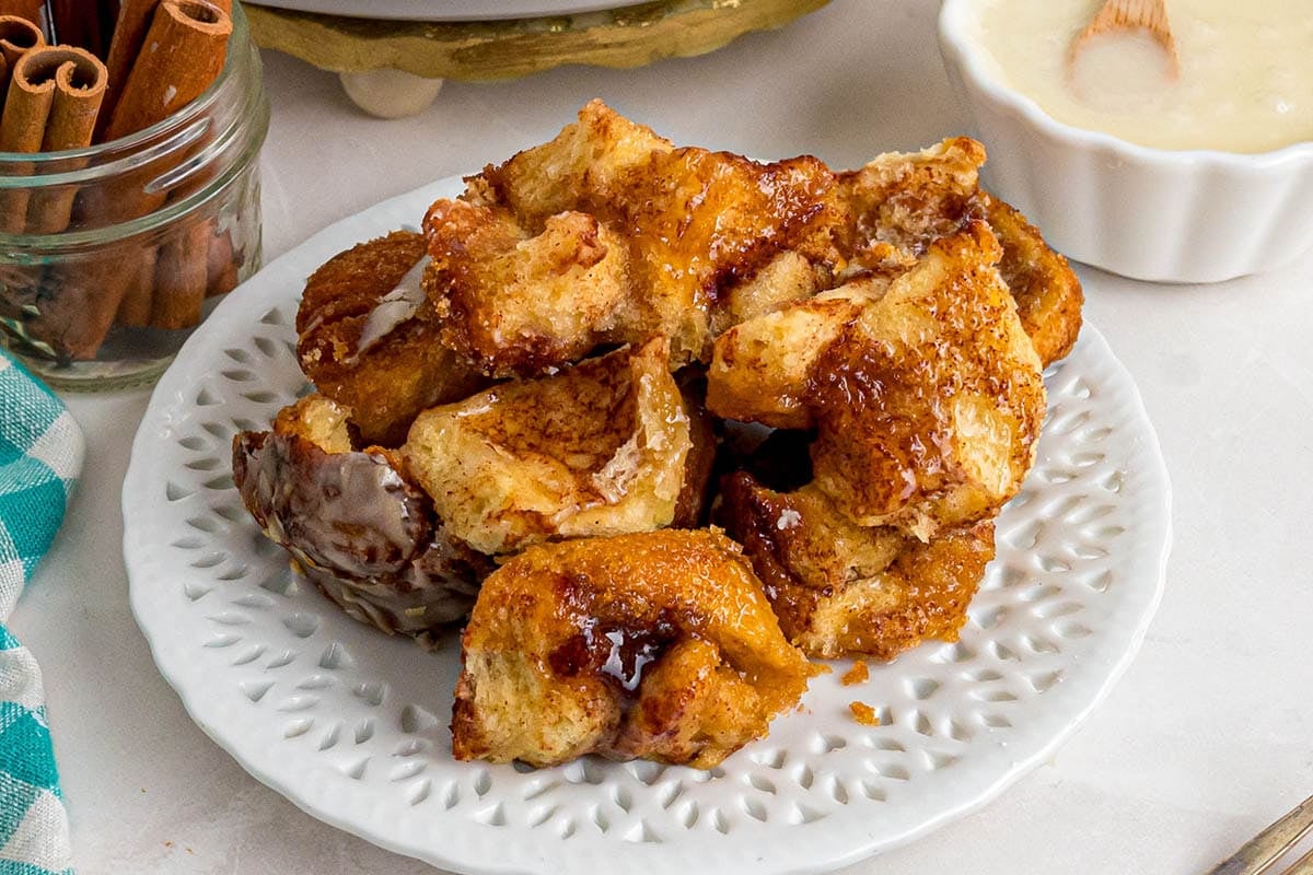 Pull-apart pieces of cinnamon roll monkey bread served on a white plate.