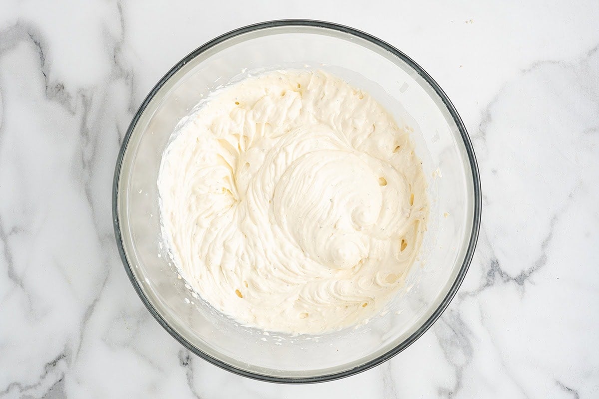 Whipped cream cheese mixture in a glass mixing bowl.