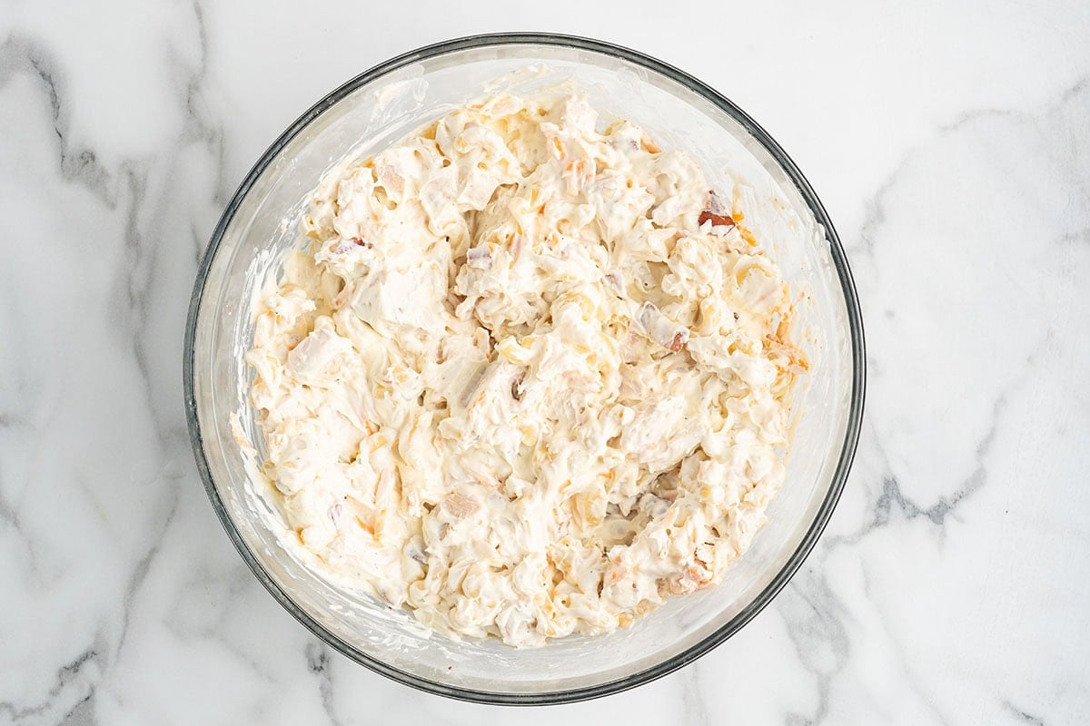 Creamy chicken and macaroni mixture combined in a mixing bowl.