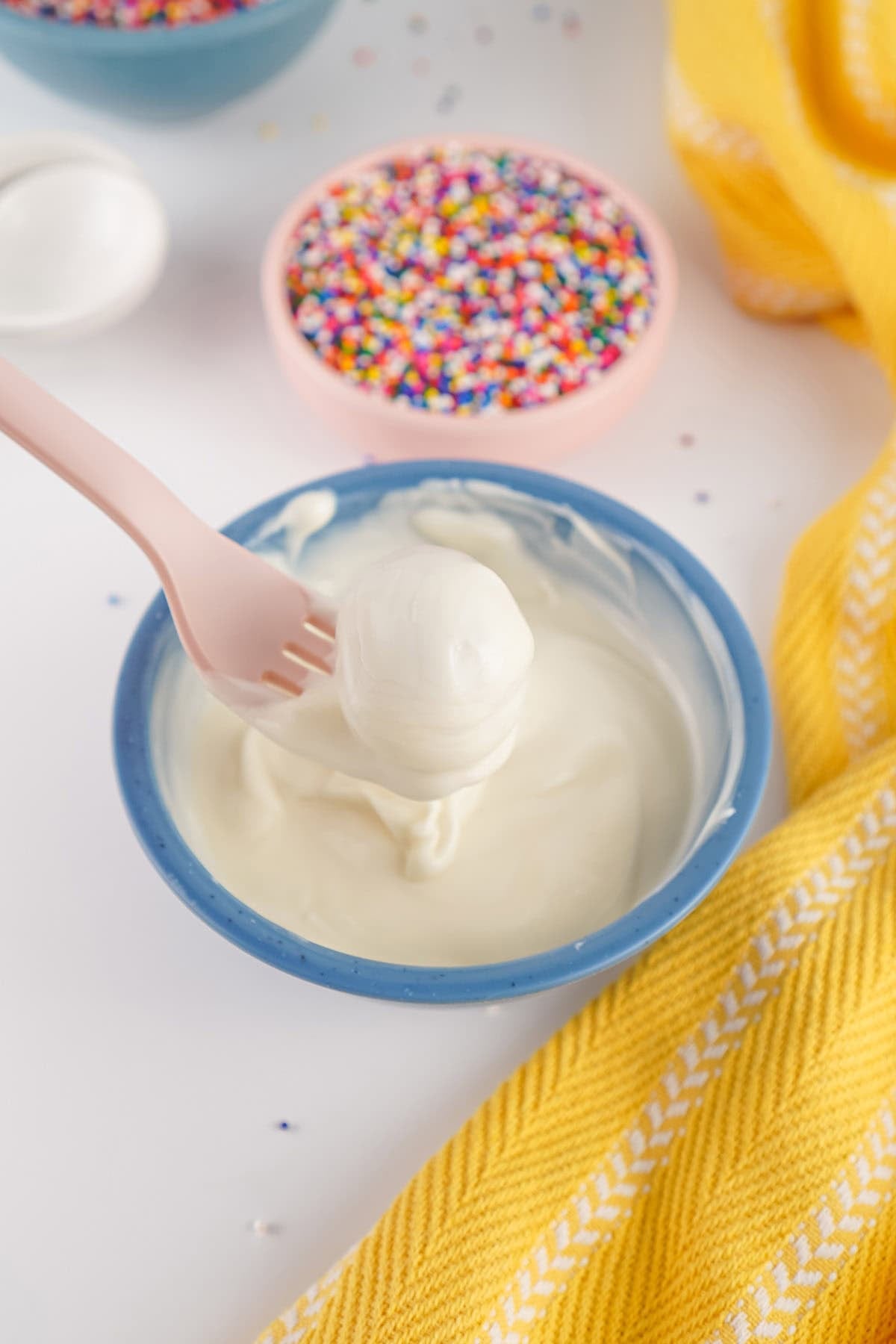 Cake ball dipped in melted white chocolate before adding sprinkles.