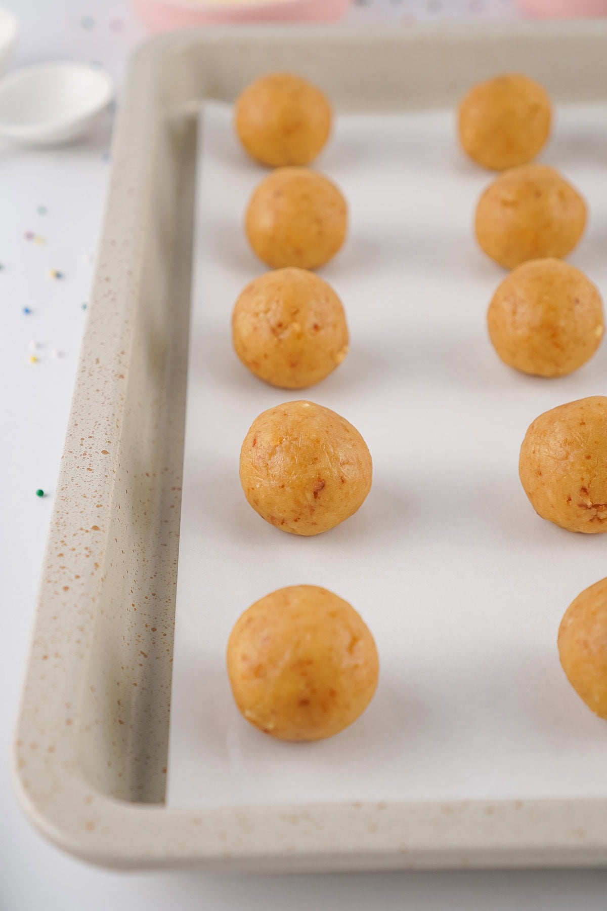 Smooth cake balls on a parchment lined baking sheet before decorating.