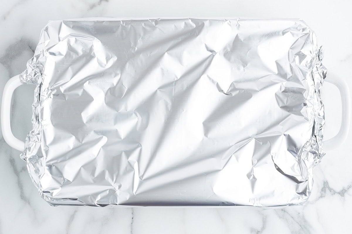 Baking dish covered tightly with aluminum foil ready to bake.