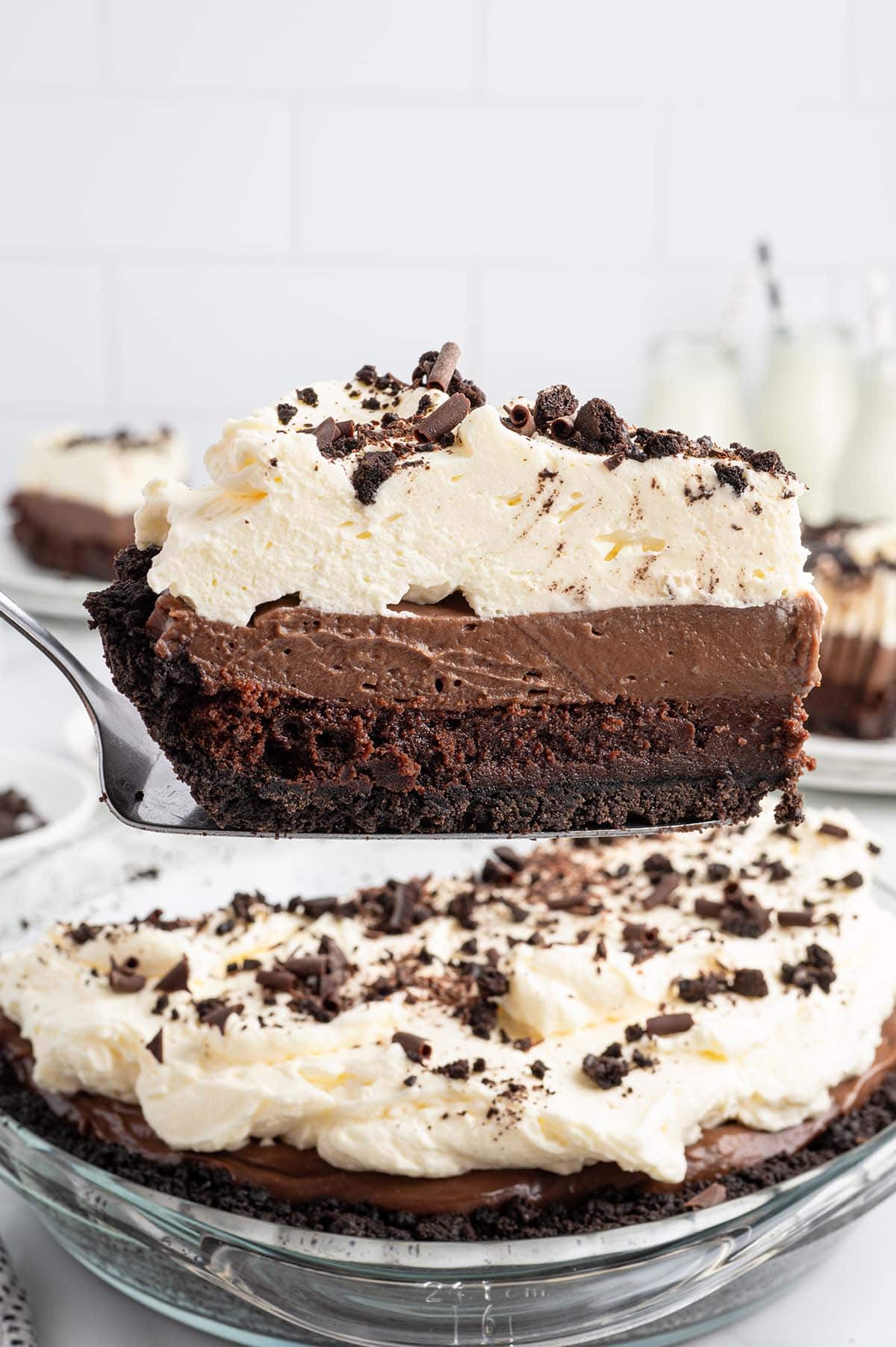 Slice of mud pie lifted from the pie plate with a pie server, showing the layered filling.