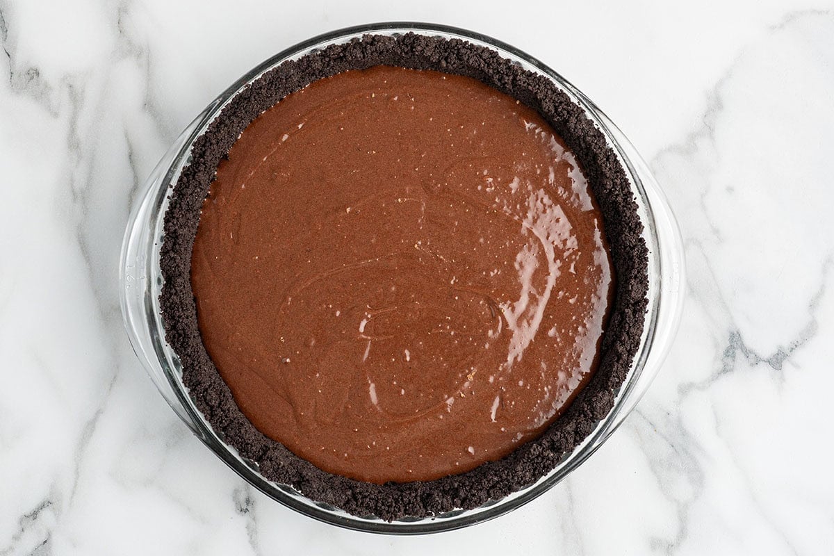 Chocolate custard filling poured into an Oreo crust before baking.
