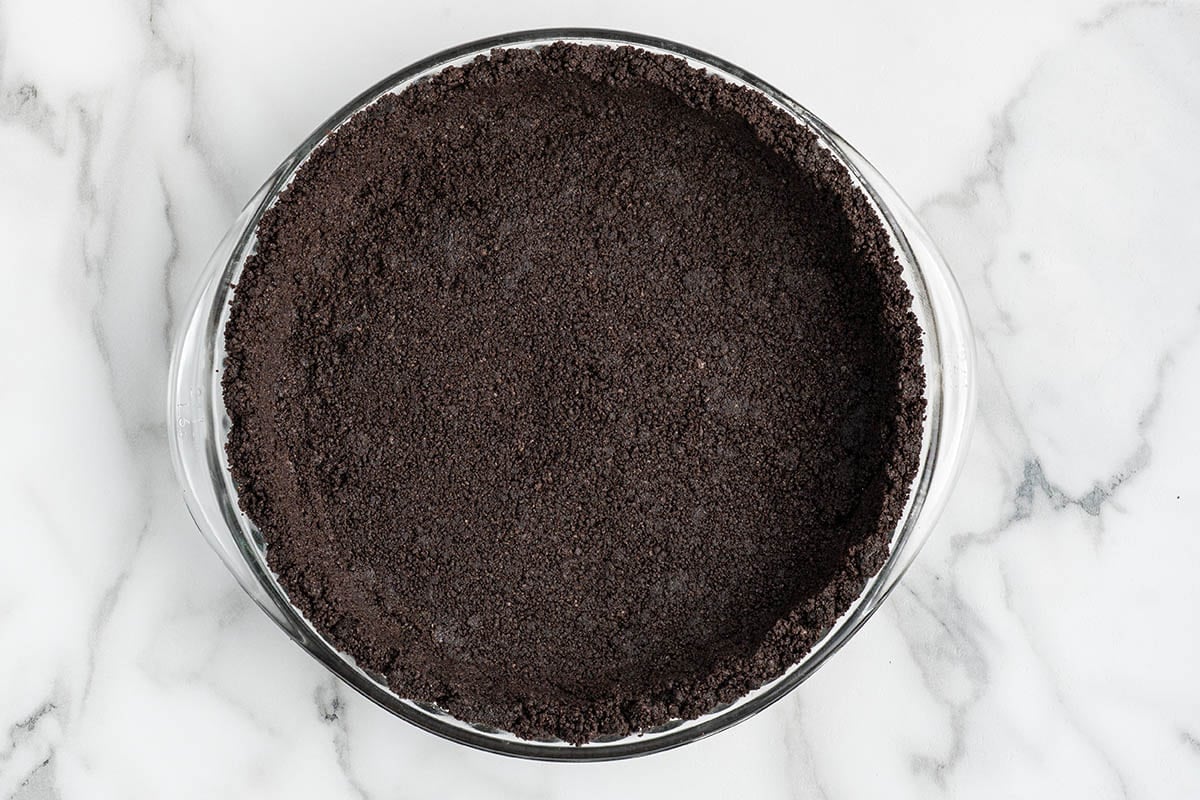 Oreo cookie crumb crust pressed into a pie dish.