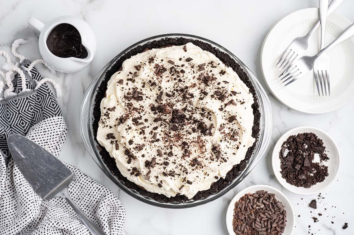 Finished mud pie topped with whipped cream and chocolate shavings, ready to serve.