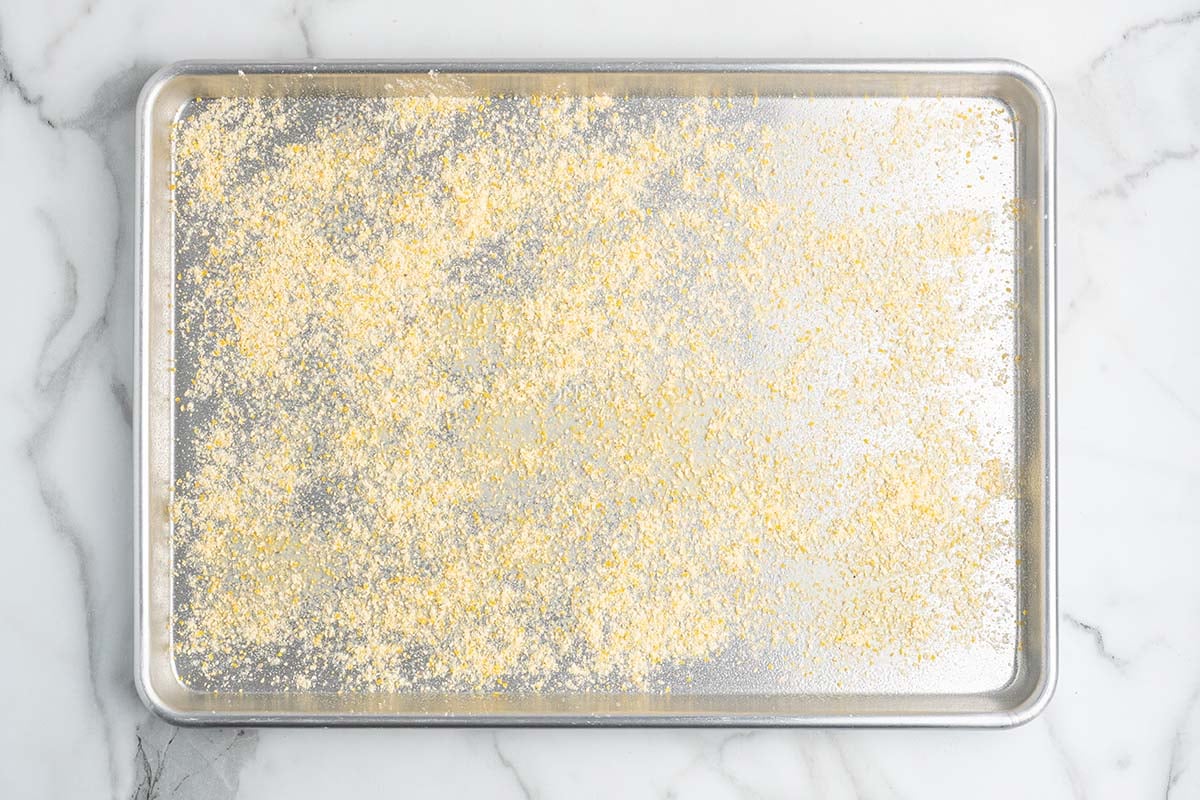 Sheet pan dusted with cornmeal, ready for pizza dough.