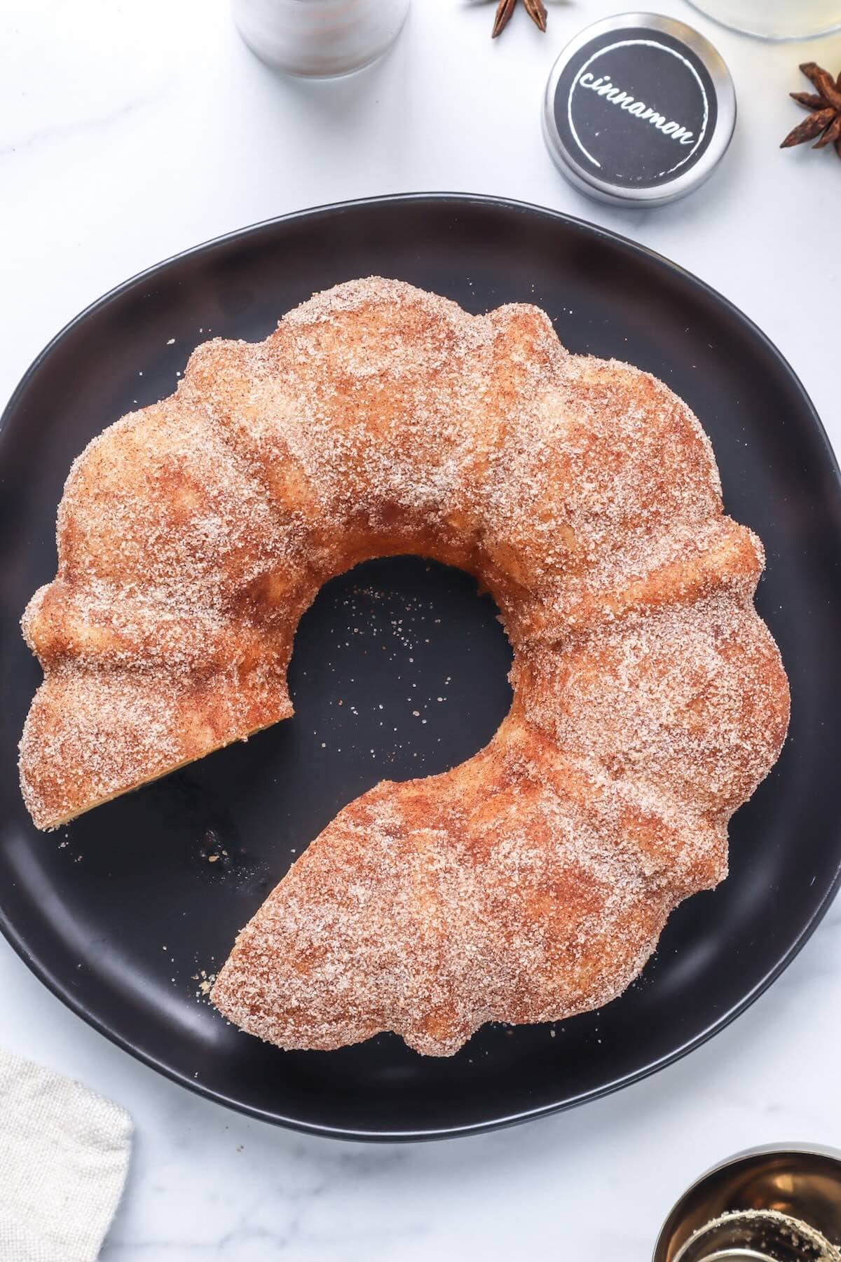 apple cider donut cake on top of black plate.