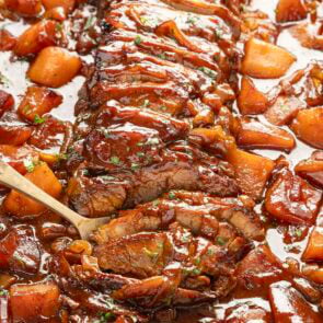 sliced beef brisket inside casserole dish with potatoes.