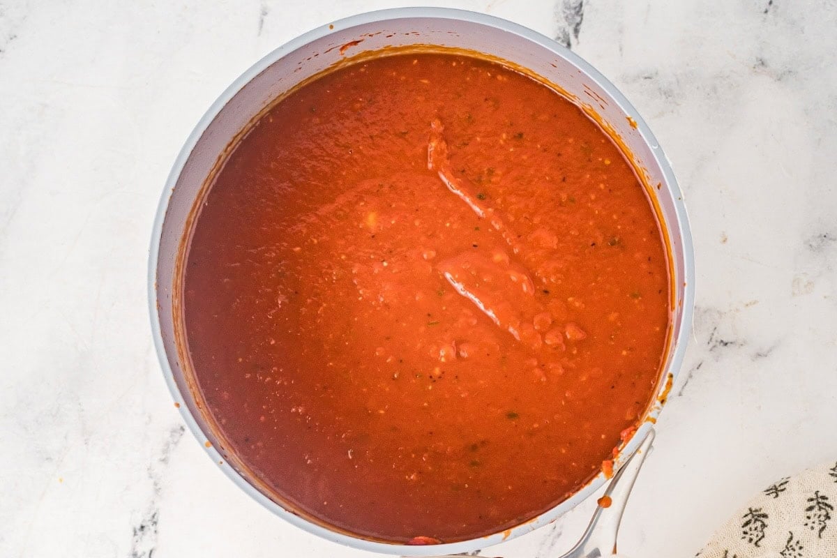 Homemade enchilada sauce in a saucepan for beef enchilada casserole.