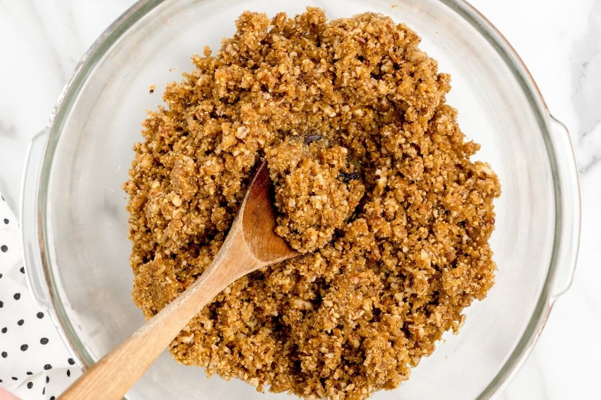 Pecan Pie Balls mixture with chopped pecans in a glass bowl.