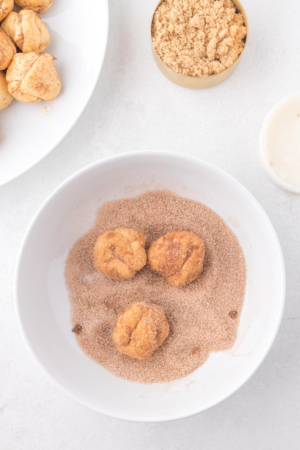Cinnamon sugar biscuit dough pieces coated before assembling slow cooker monkey bread.